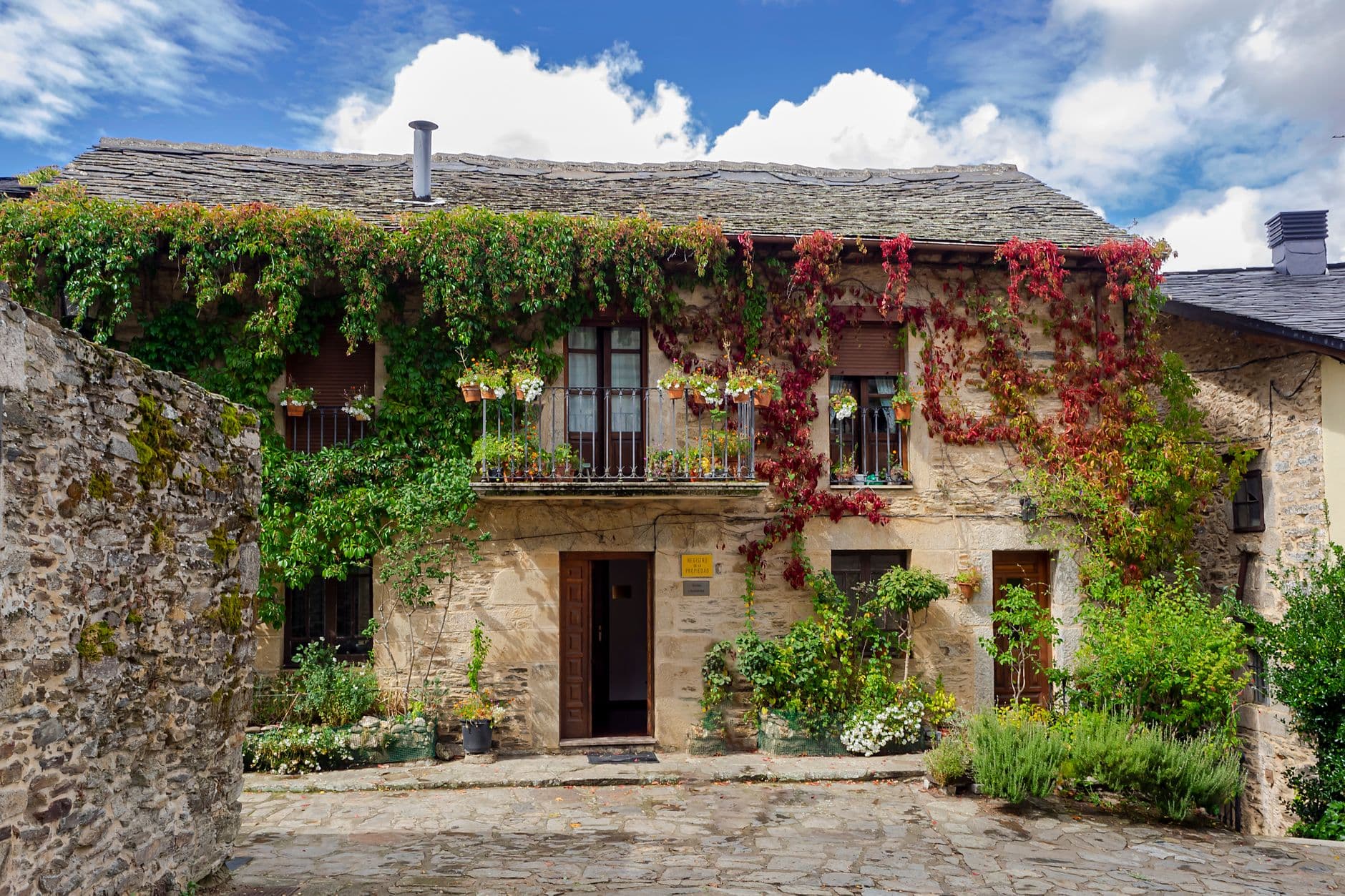 Casa de piedra cubierta de hiedra en el entorno verde y húmedo del norte de España